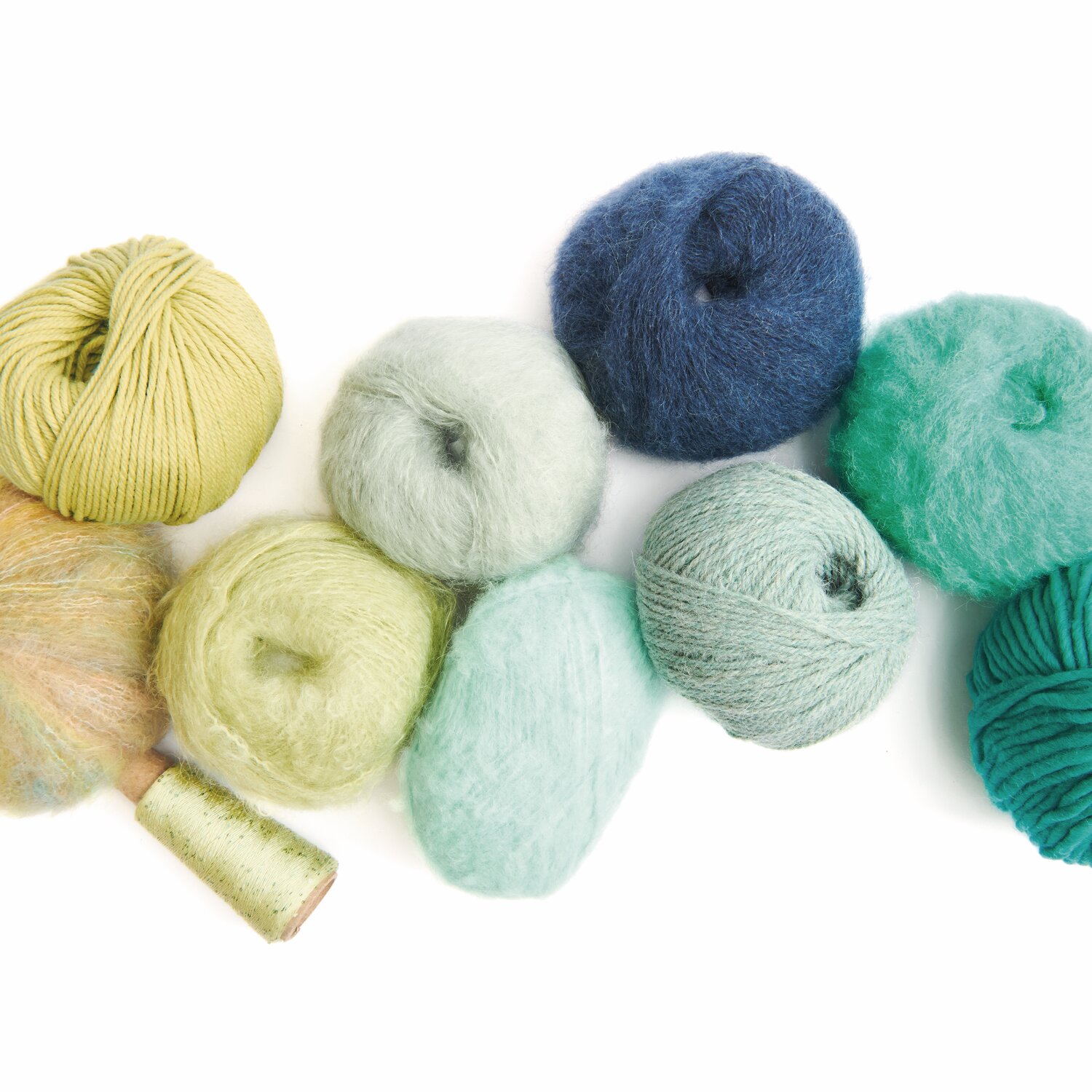 Made by Me No. 21 Herbst-Winter: Verschiedene Wollknäuel in Grün- und Blautönen von Rico Design.