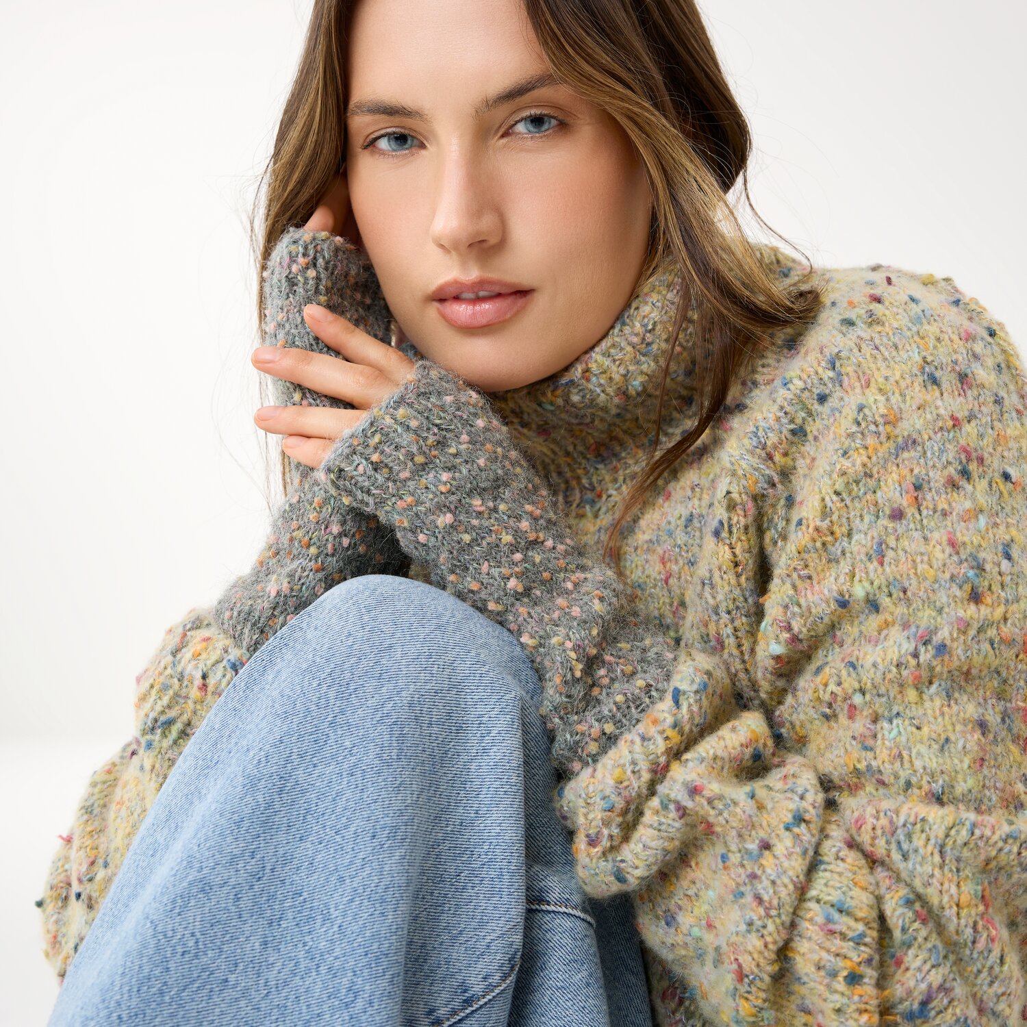 Strickset Stulpen Modell 17 aus Die Neue Masche No. 16, grob gestrickte melierte Handstulpen, getragen von Frau im gemütlichen Oversize-Pullover und Jeans