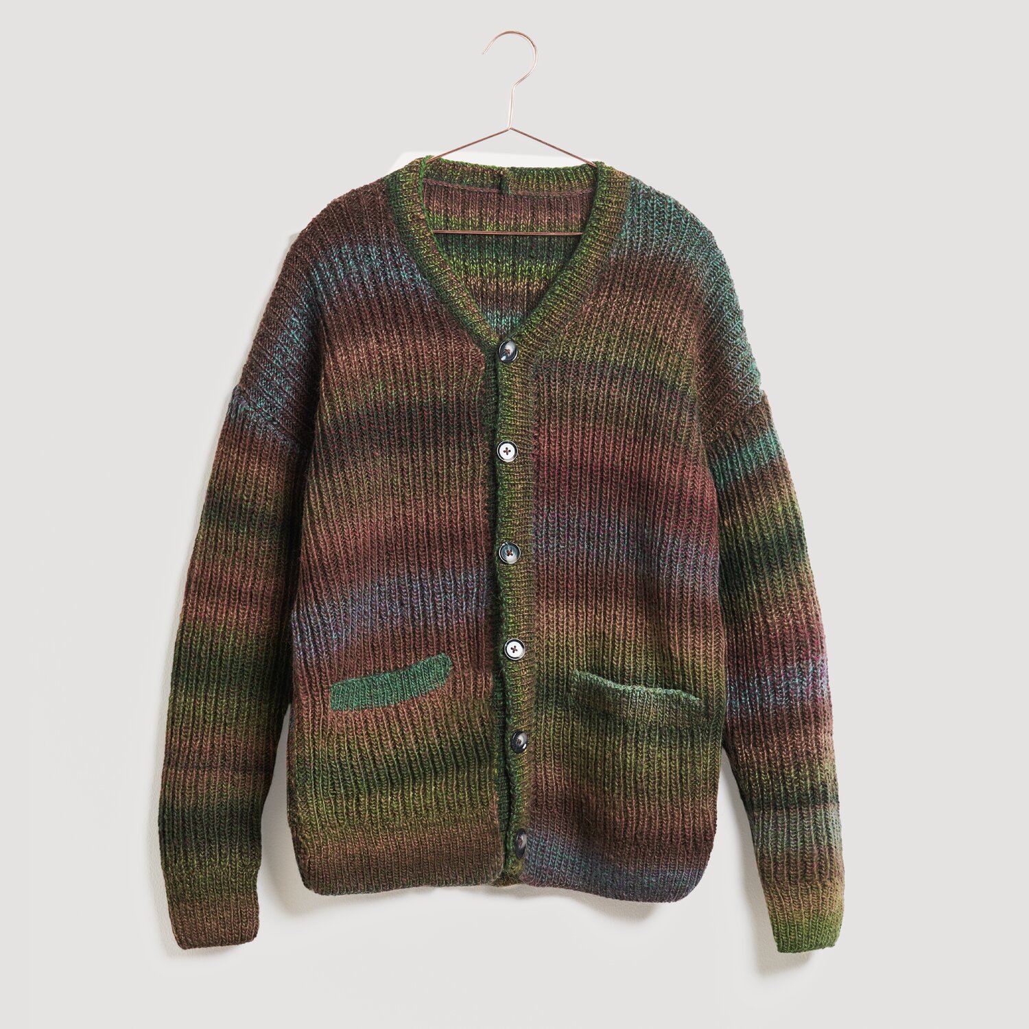 Strickjacke in Erdtönen, Modell Legeware. Die Jacke hat einen V-Ausschnitt, Knopfleiste und zwei Taschen. Ideal für kühle Tage, bietet sie Komfort und Stil.