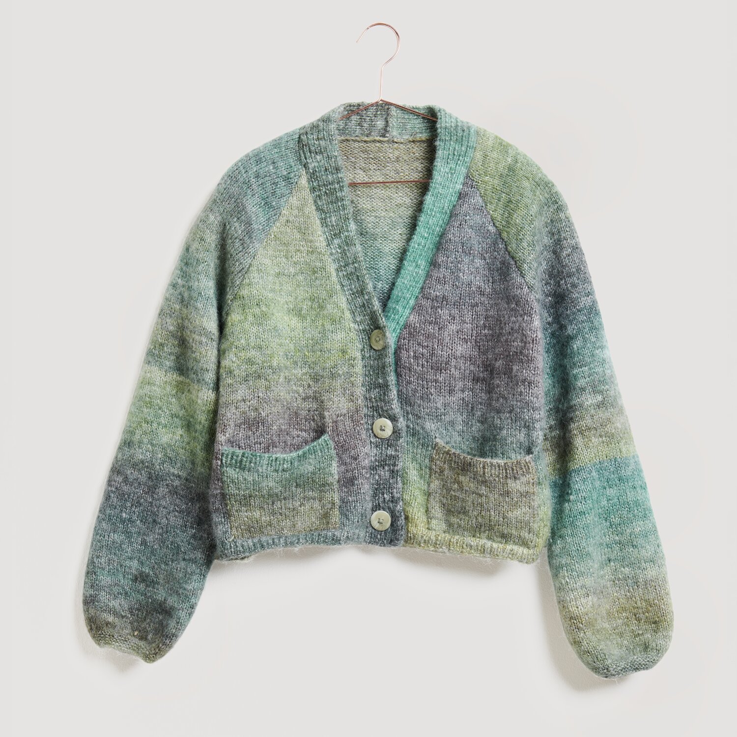 Strickjacke in sanften Blau- und Grüntönen, Modell Legeware. Die Jacke hat einen V-Ausschnitt, Knöpfe und zwei Taschen. Perfekt für einen gemütlichen, stilvollen Look.
