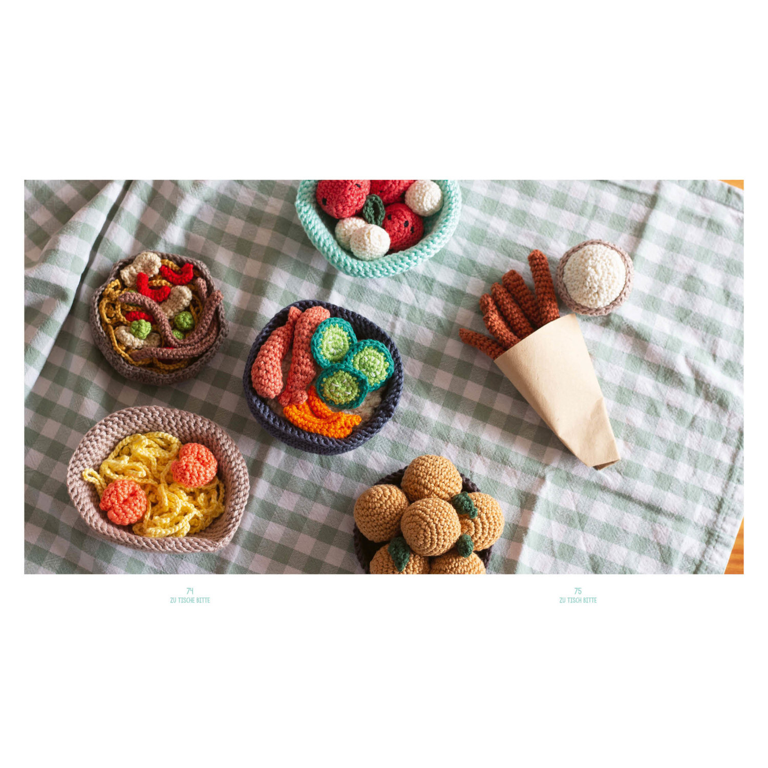 Meine Häkelküche: Bunte gehäkelte Lebensmittel auf kariertem Tuch, ideal für kreative Spielküchen.