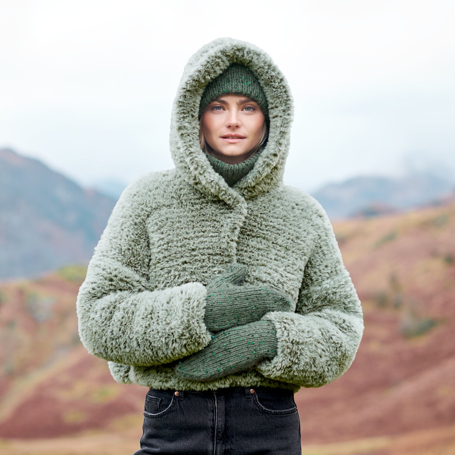 Strickset Handschuhe + Mütze Modell 02 + 03 aus Lovewool No. 23, warmes Set mit grobgestrickter Mütze und Fäustlingen, getragen von Frau vor herbstlicher Berglandschaft