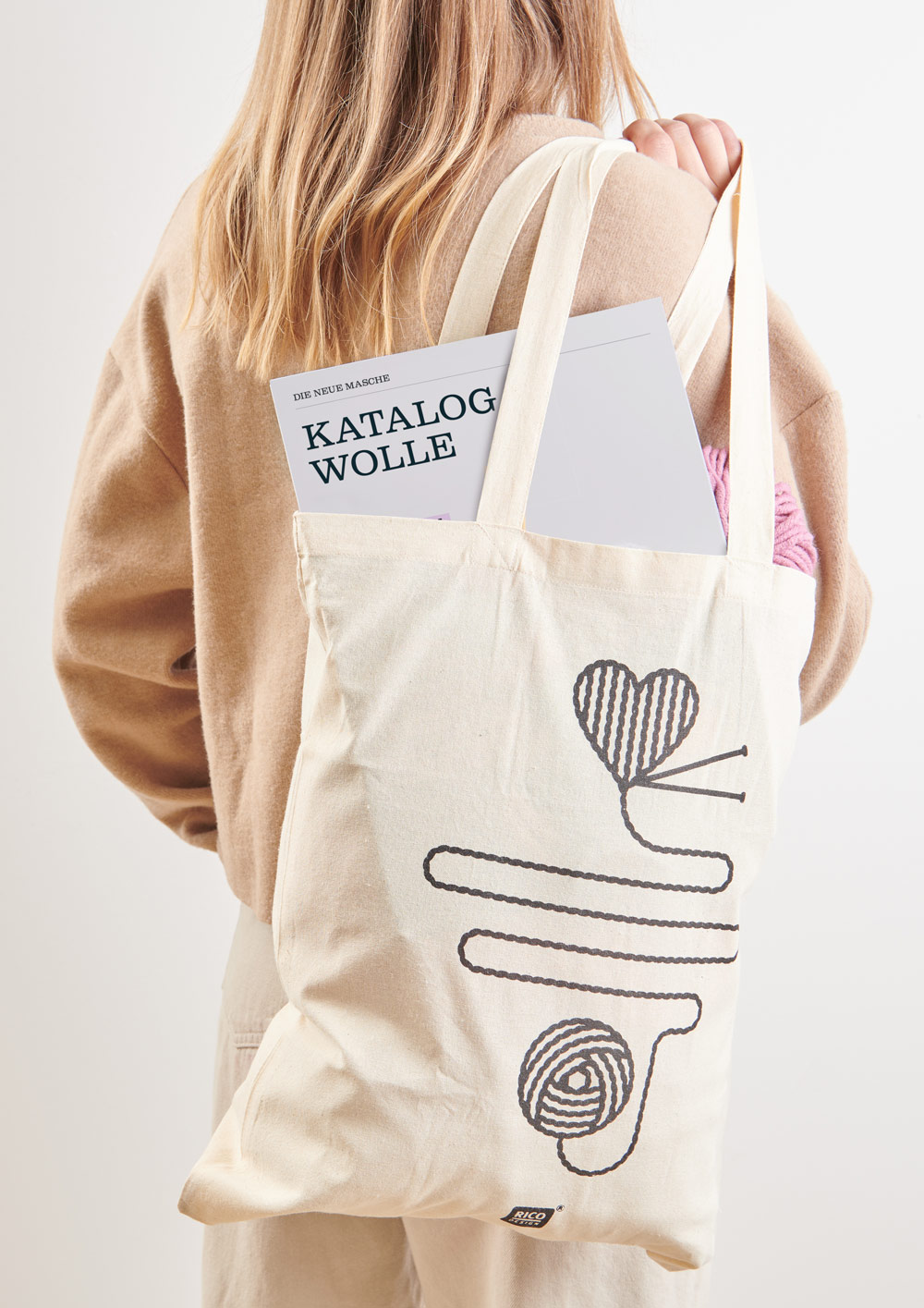 Katalog Wolle in Beutel - getragen von einer blonden Frau Frau trägt Jutebeutel über der Schulter wo ein Katalog Wolle raus schaut