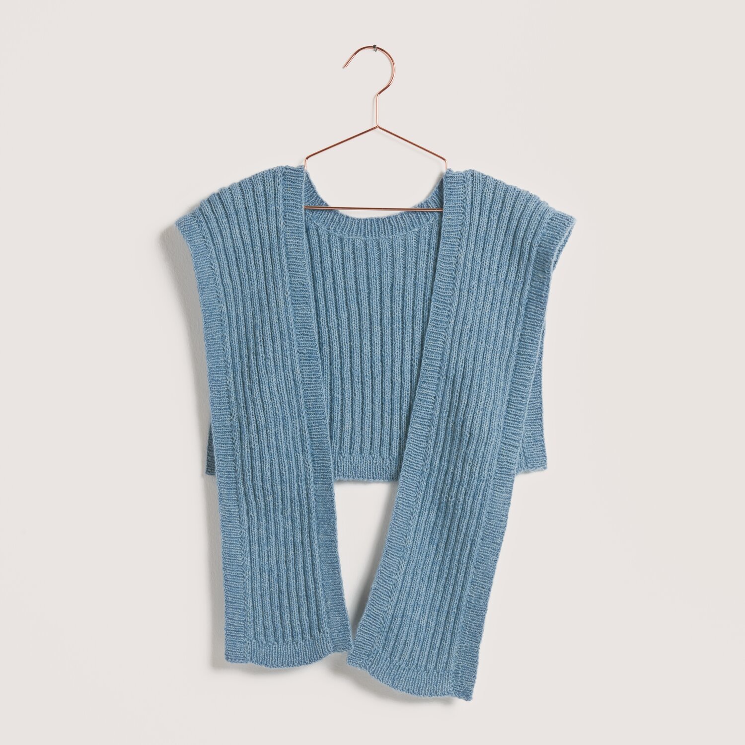 Made by Me No. 22 Frühjahr-Sommer: Taubenblauer Strickpullover aus Creative Cotton Fleece dk, präsentiert auf einem Kleiderbügel.