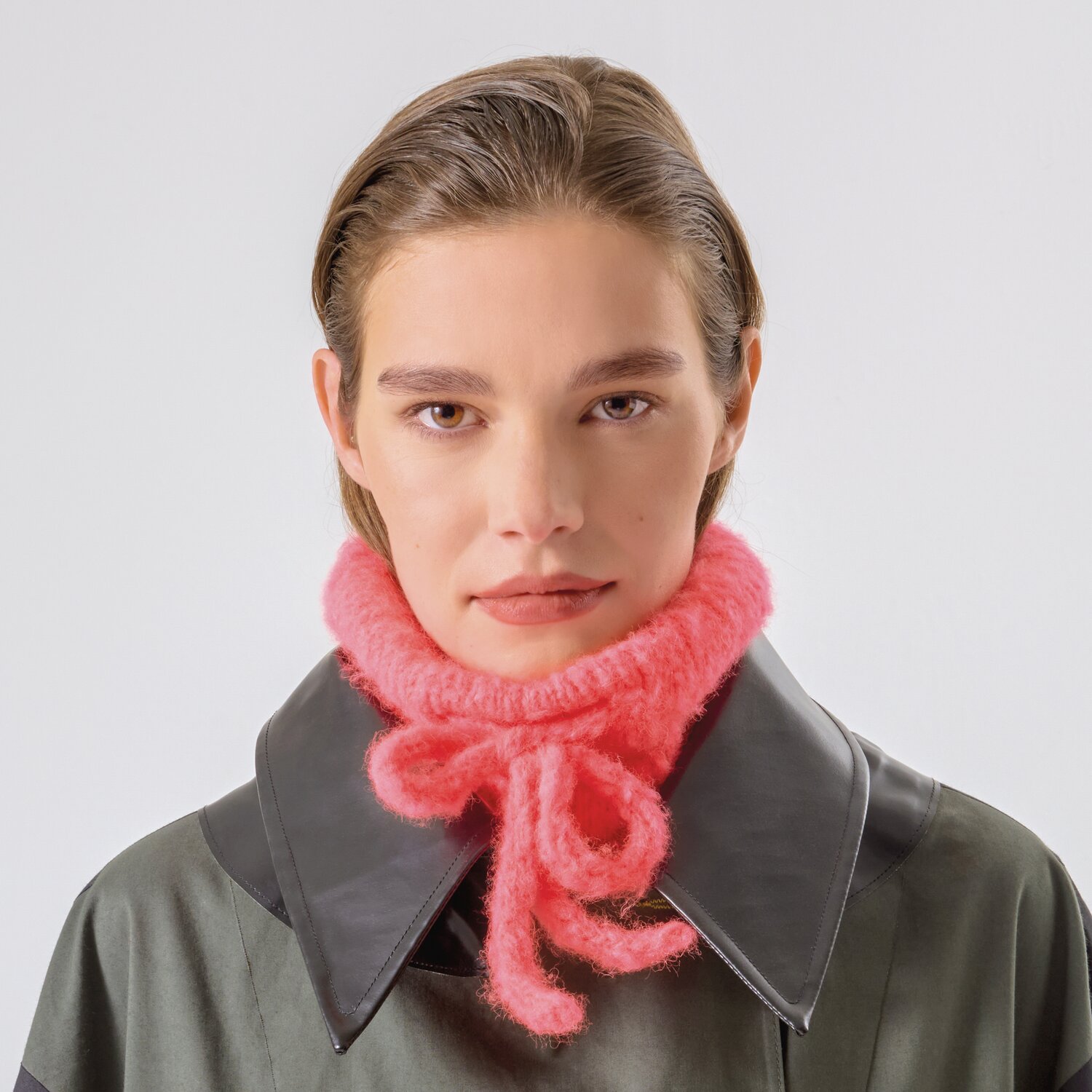 Strickset Kragen Modell 20b aus Made by Me No. 21: Frau trägt pinken Strickkragen über dunklem Mantel.