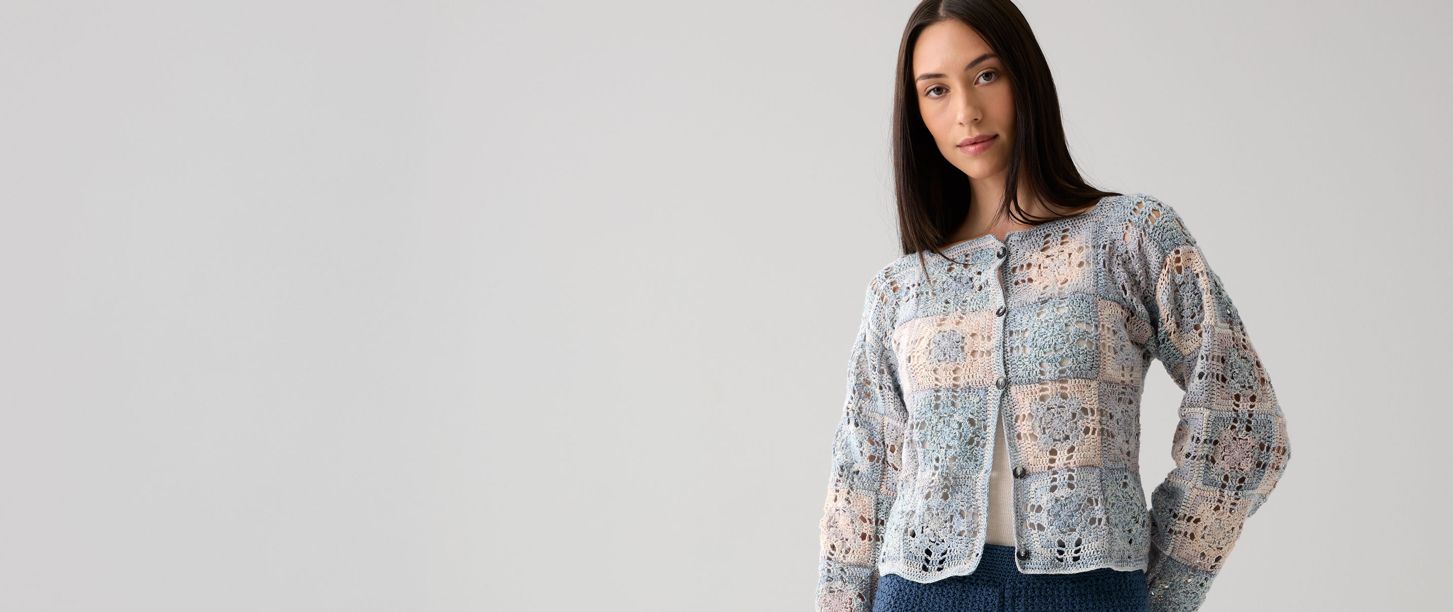 Frau trägt pastellfarbene Häkeljacke