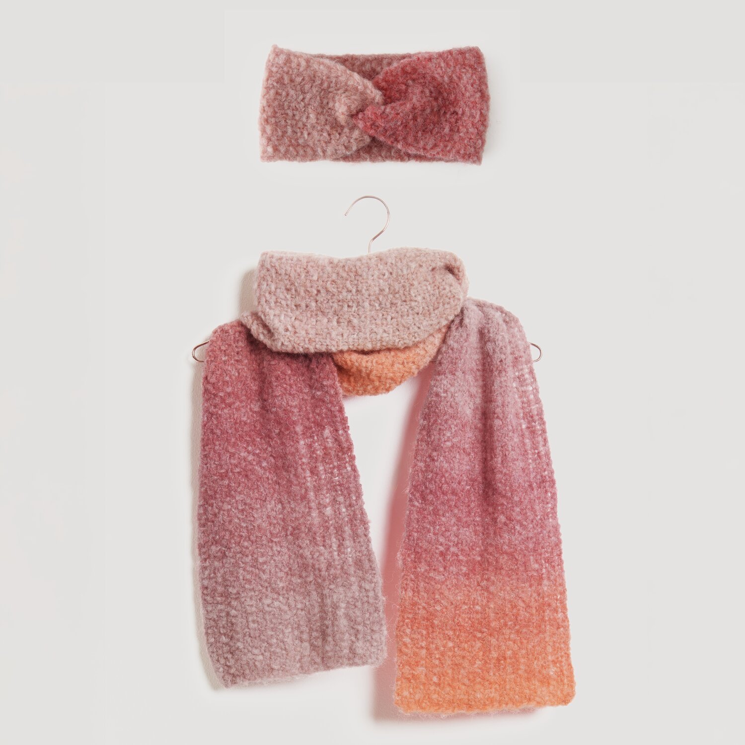 Stirnband und Schal in sanften Rosa- und Orangetönen, aus weichem Material. Perfekt für kühle Tage. Modell Legeware, ideal für stilvolle Herbst- und Winteroutfits.
