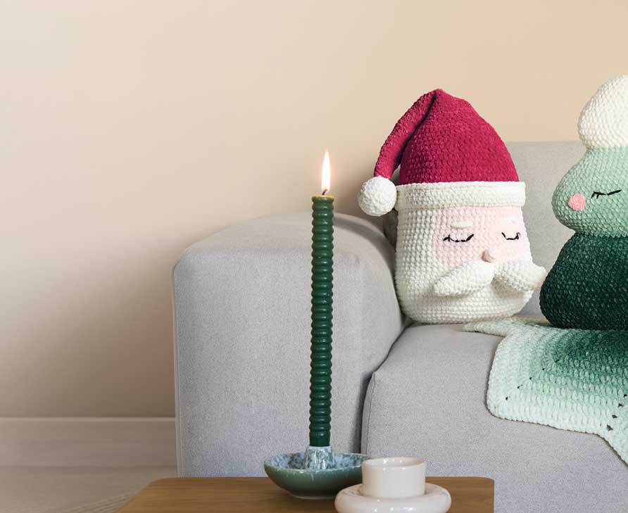 Gehäkelter Weihnachtsmann und gehäkelter Tannenbaum auf Sofa