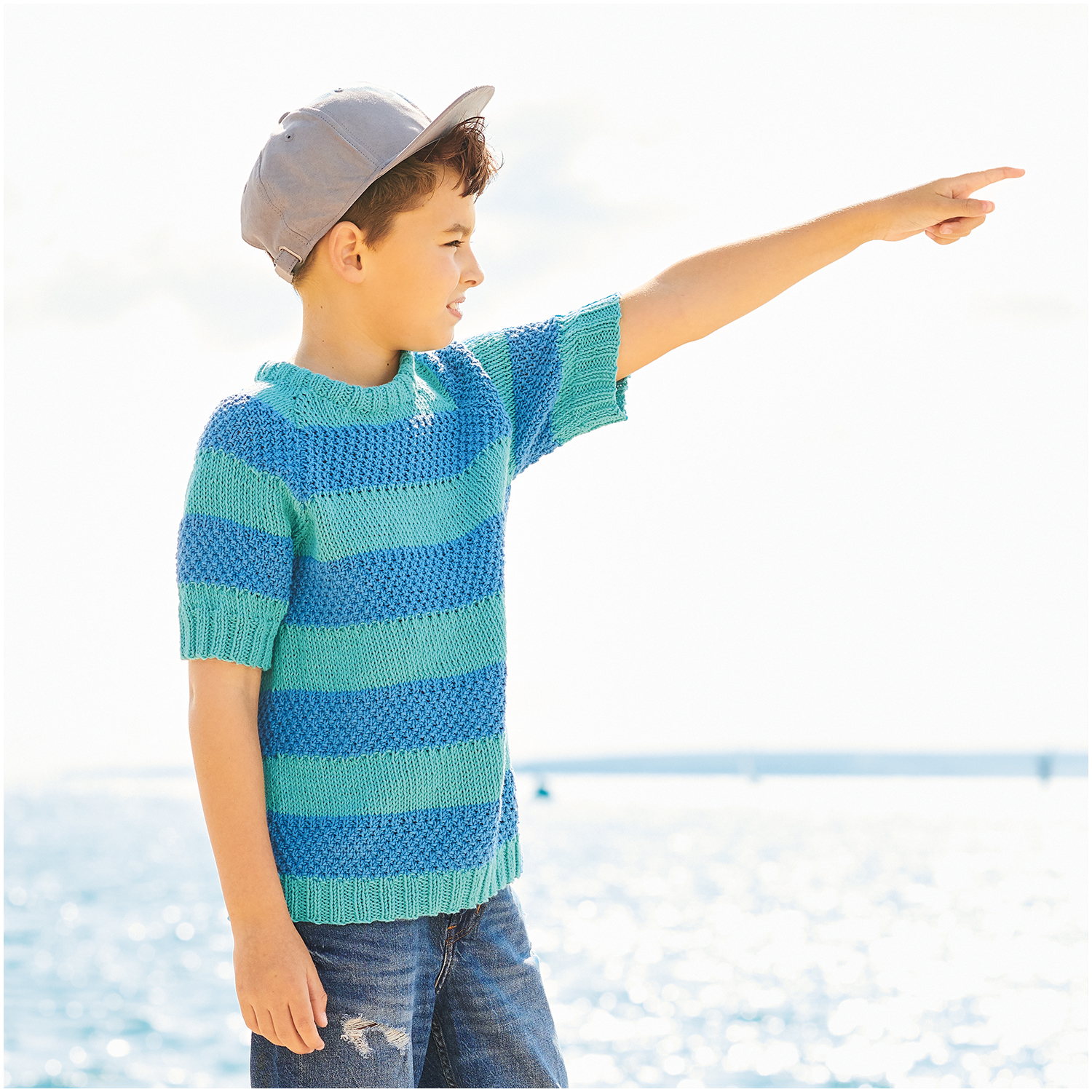 Essentials Organic Cotton aran: Junge am Meer in gestreiftem Strickpullover, himmelblau, von Rico Design.