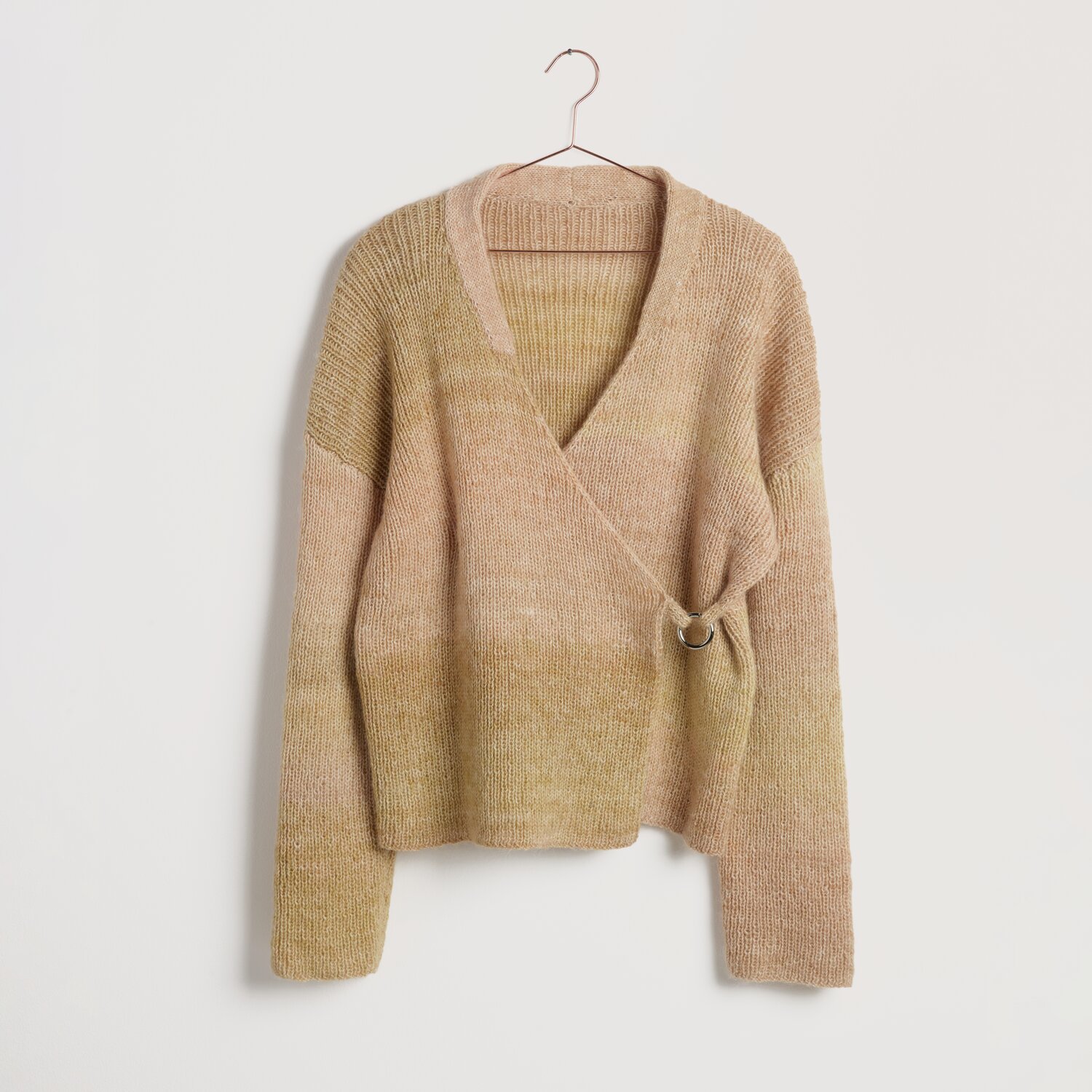 Strickset Jacke Modell 17 aus Lovewool No. 22 in sanften Erdtönen, hängend an einem Kleiderbügel. Ideal für Frühjahr-Sommer.