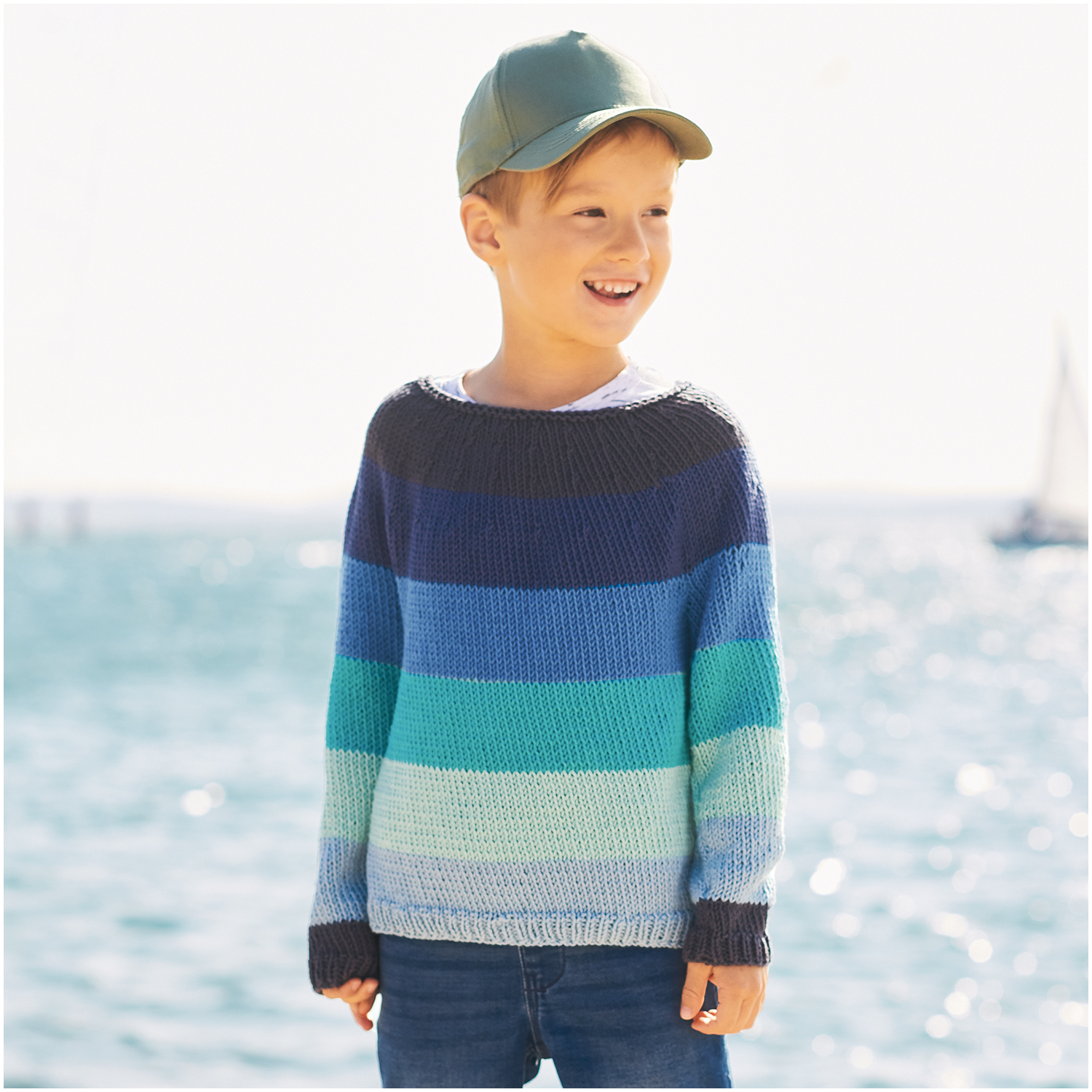 Essentials Organic Cotton aran: Junge in gestreiftem Pullover am Meer, Rico Design, türkis, 50g 90m.