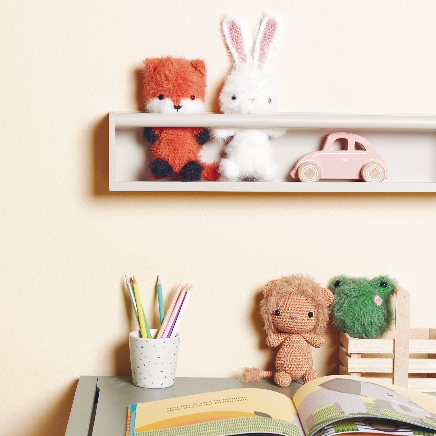 Creative Ricorumi dk 25g Farbe Fuchs von Rico Design Ricorumi Furry Animals auf Regal mit Fuchs und Hase, daneben rosa Auto. Tisch mit Stiften und Buch.