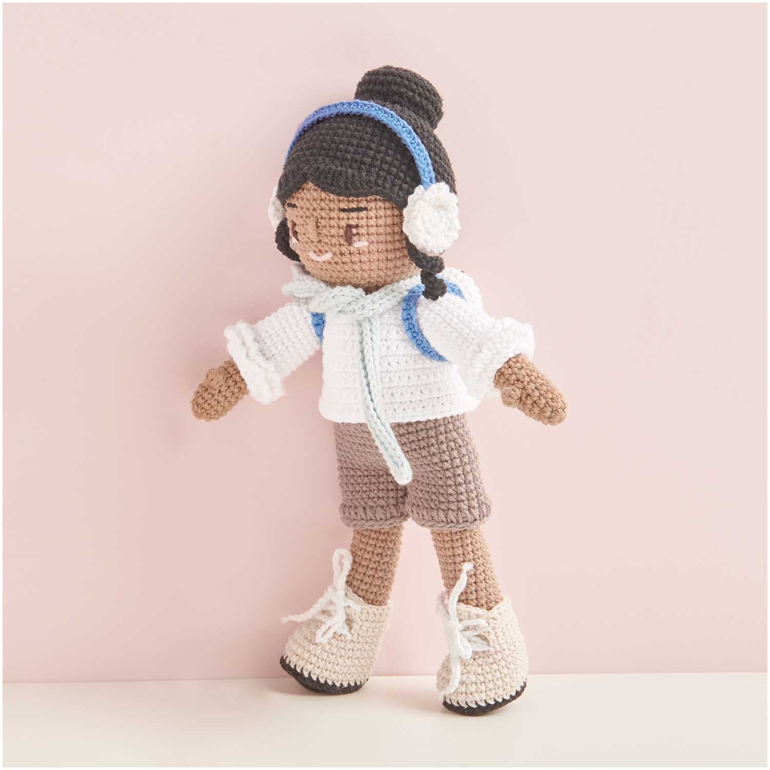 Creative Ricorumi dk 25g Farbe Holz von Rico Design Creative Ricorumi dk: Gehäkelte Puppe mit weißem Pullover, blauen Kopfhörern und beigen Stiefeln.