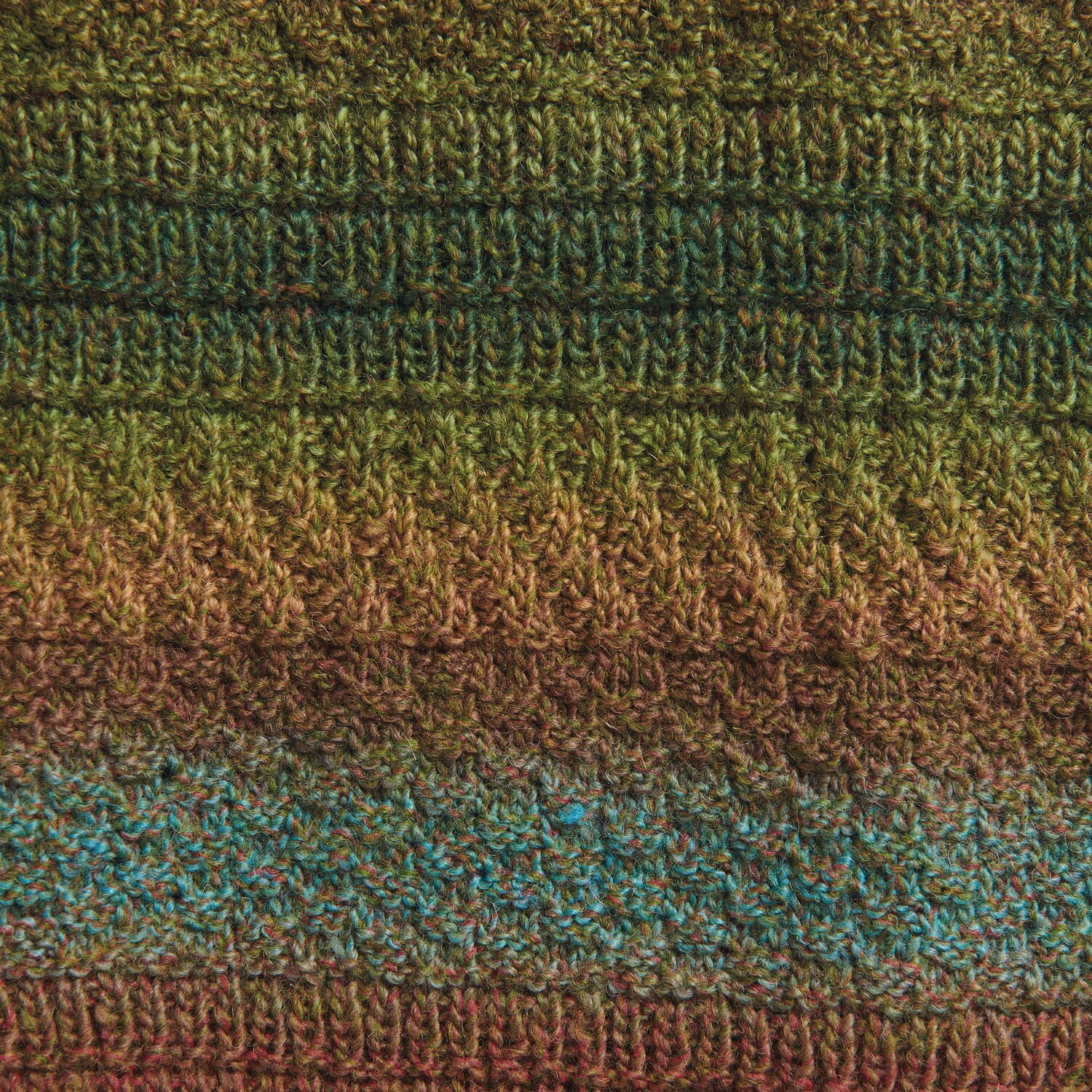 Creative Melange Alpaca Wonderball dk zeigt ein gestricktes Muster in Grün- und Brauntönen. Ideal für Herbstprojekte.