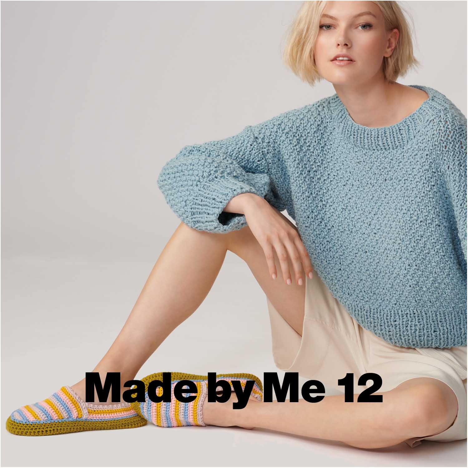 Essentials Organic Cotton aran: Frau in gestricktem Pullover und gestreiften Hausschuhen von Rico Design.