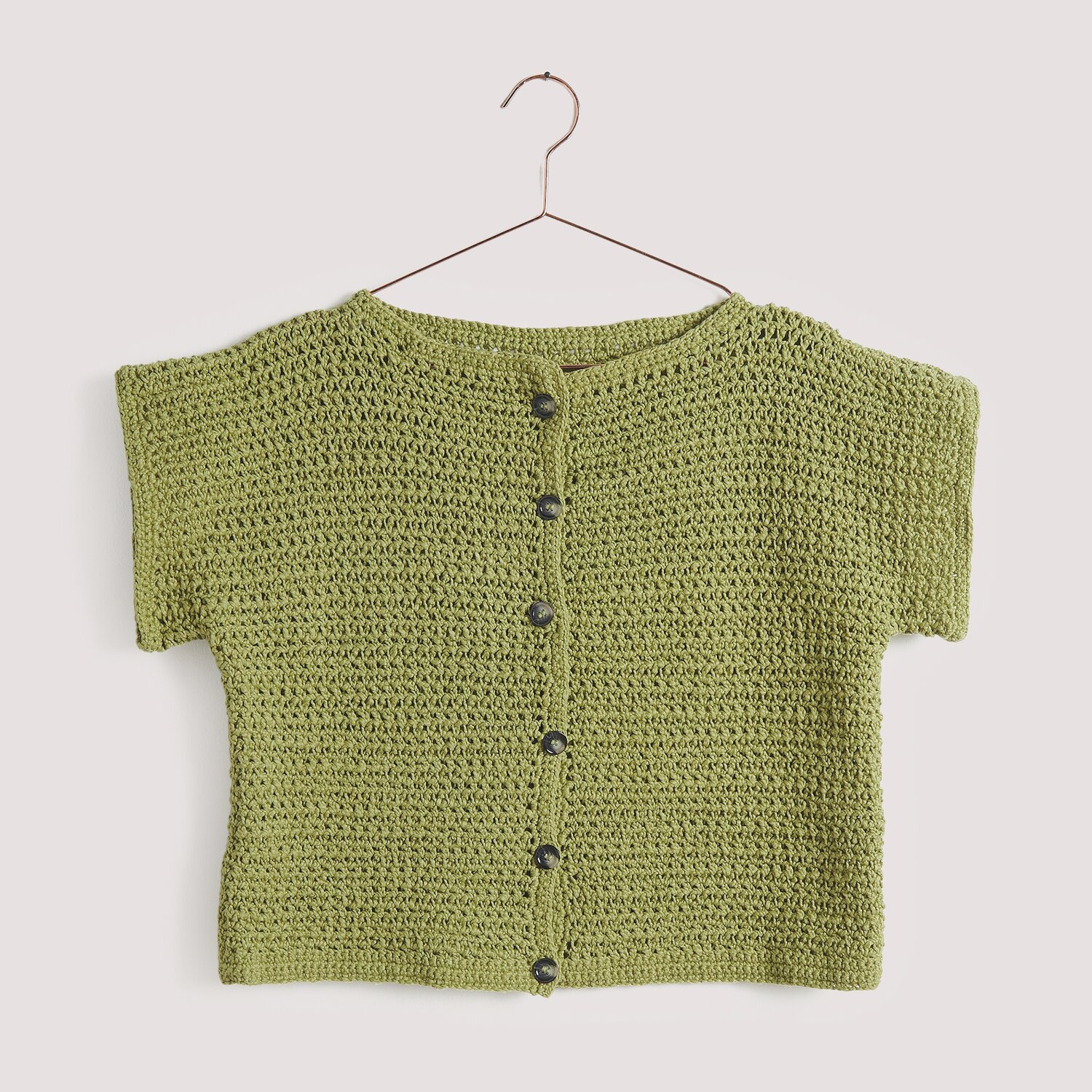 Häkelset Weste Modell 10 aus Die Neue Masche No. 15, olivgrün, mit Knopfleiste auf einem Kleiderbügel.