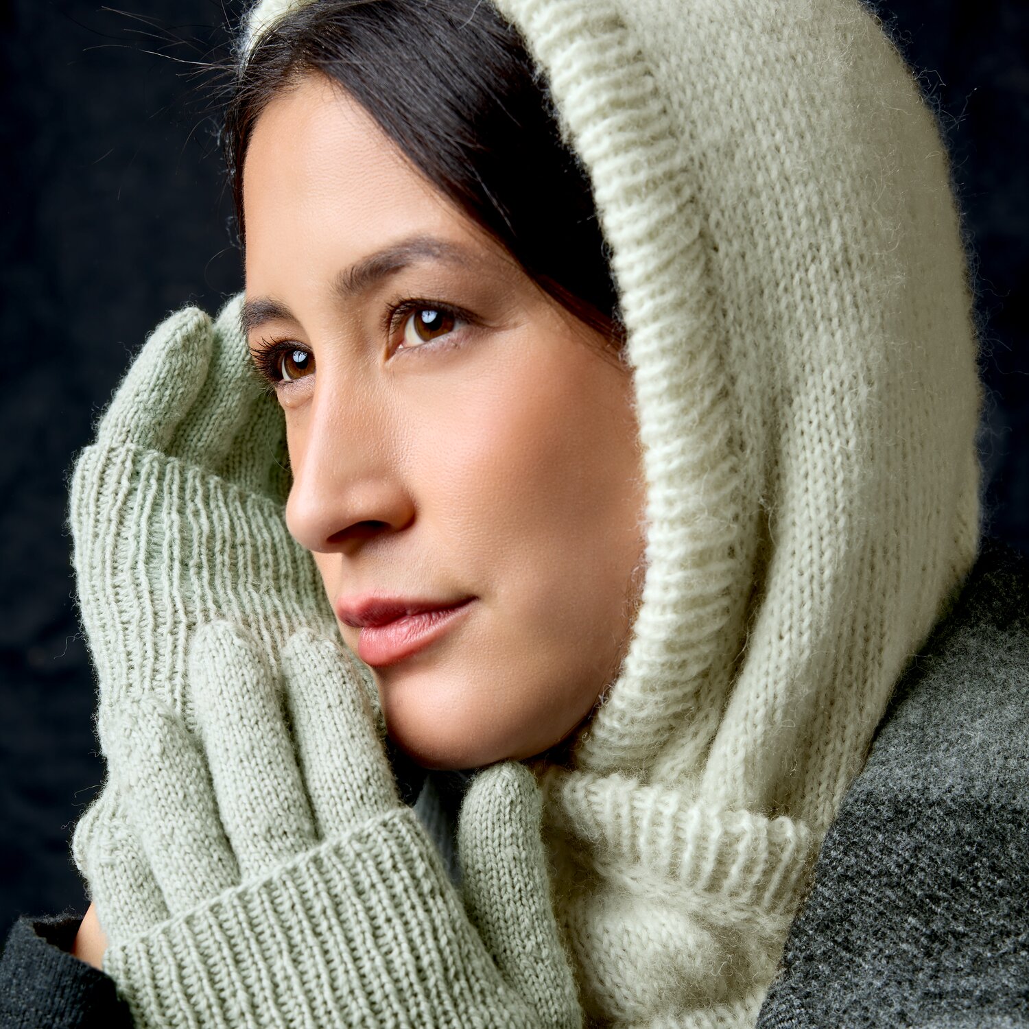 Strickset Handschuhe Modell 01 aus Luxury Knits Little Pieces, weiche hellgrau-grüne Strickhandschuhe mit passender Kapuze, nahes Porträt einer Frau