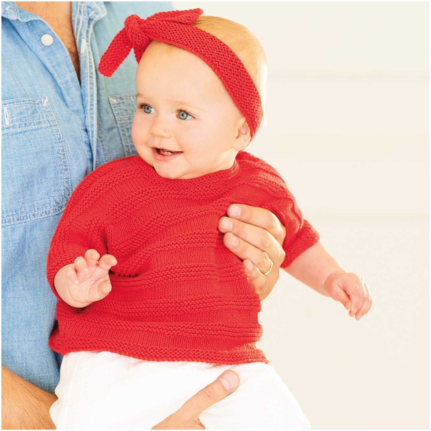 Baby Organic Cotton: Ein Baby trägt ein gestricktes, himbeerfarbenes Outfit von Rico Design.