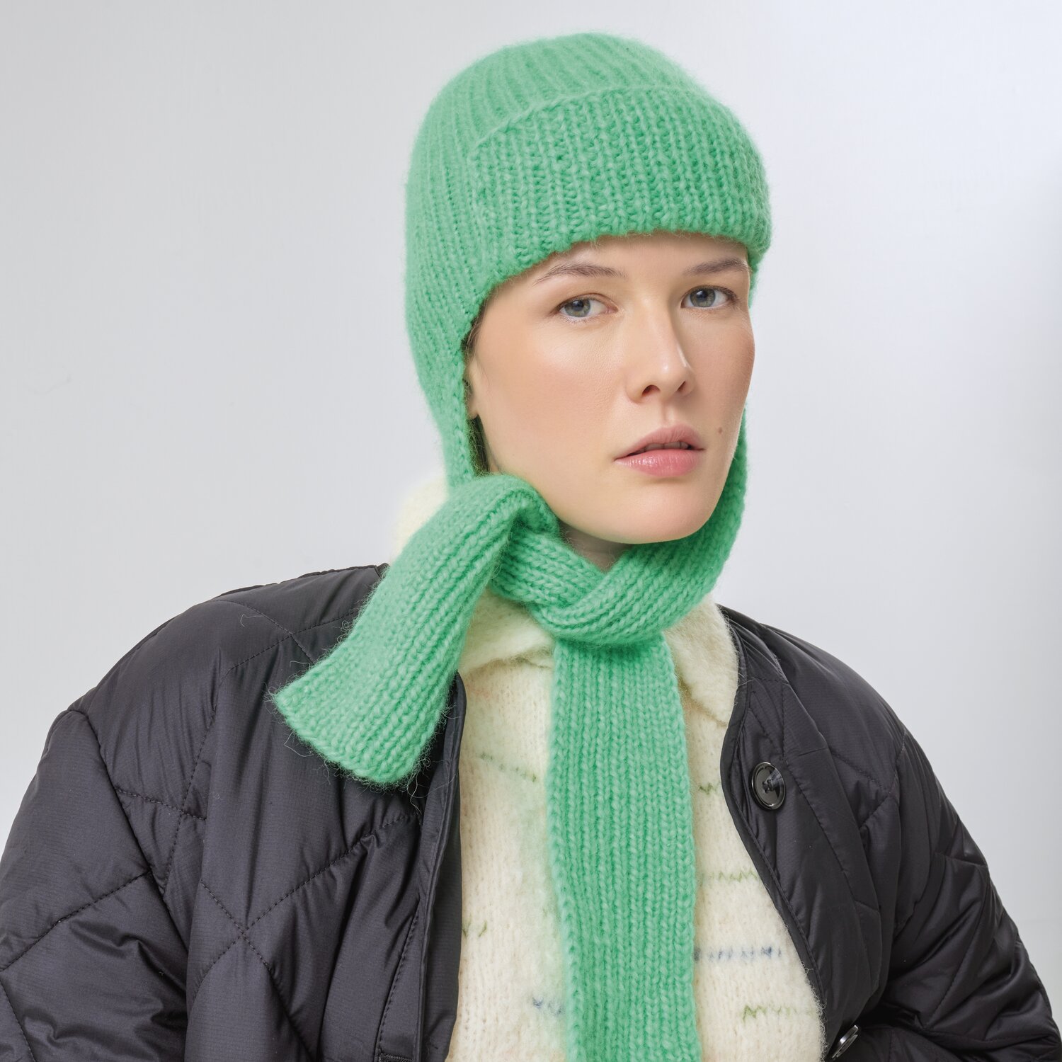 Strickset Mütze Modell 19 aus Made by Me No. 21: Frau trägt grüne Strickmütze und Schal.