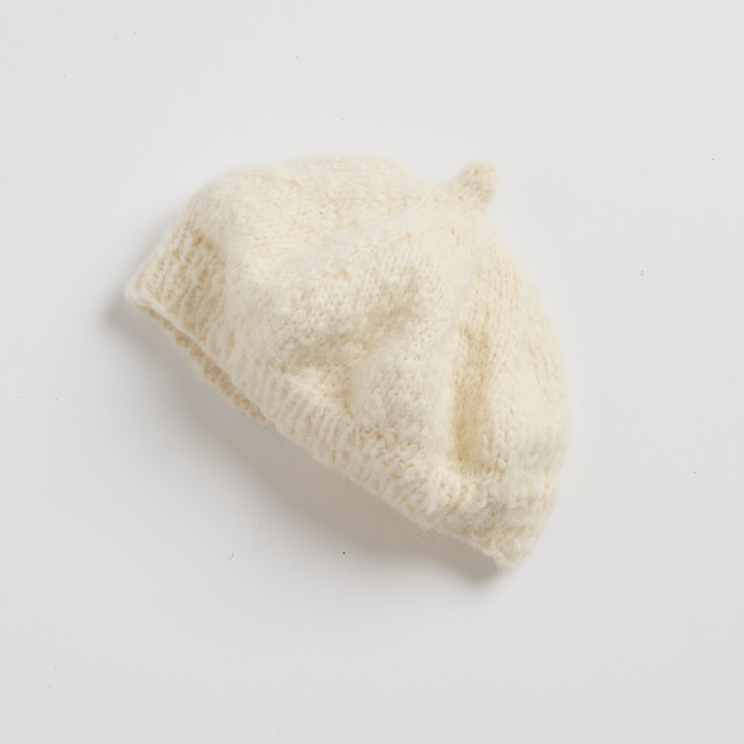 Strickset Barret Modell 18 aus Luxury Knits Little Pieces, weiches handgestricktes Barett in hellem Naturton, locker strukturiertes Garn auf neutralem Hintergrund