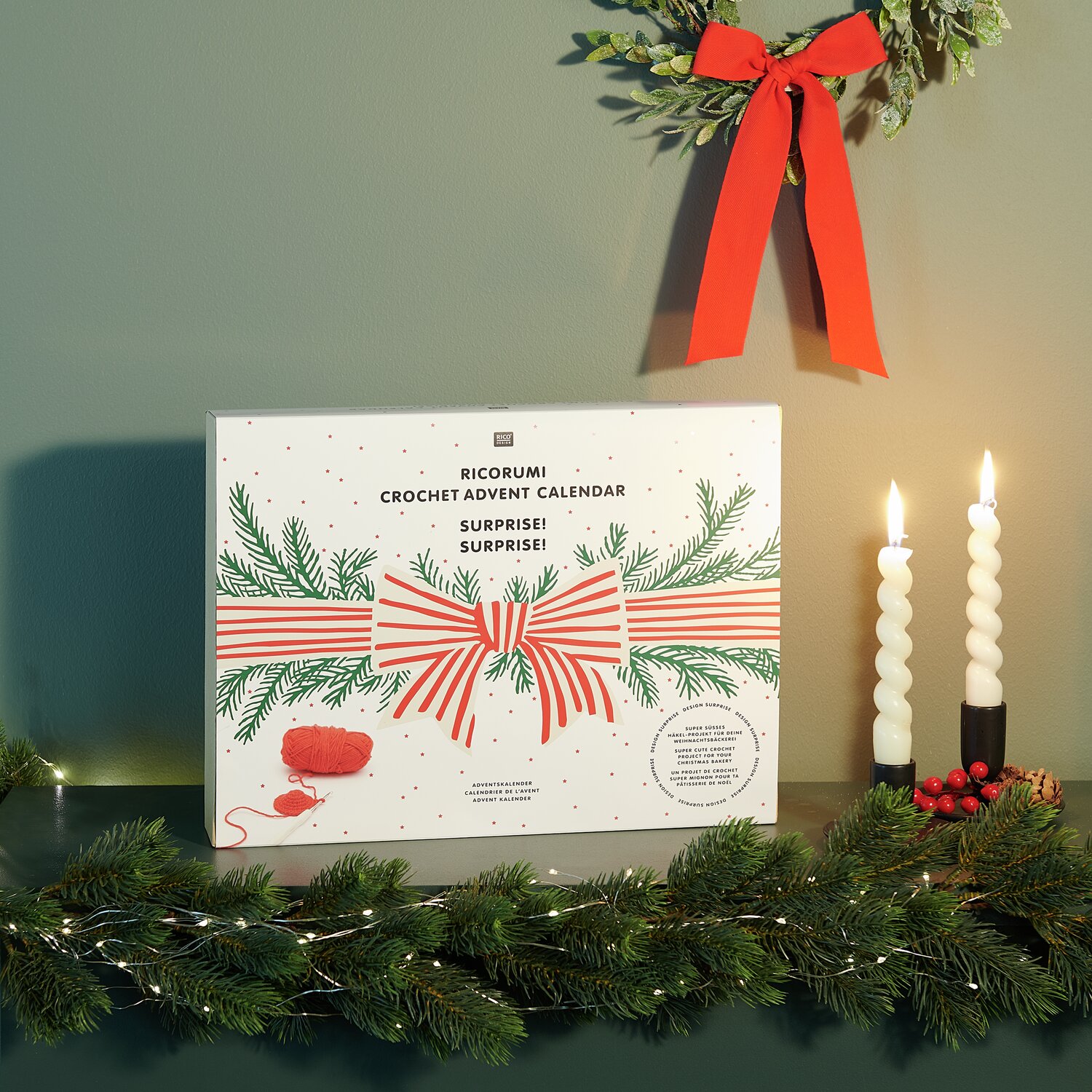 Ricorumi Adventskalender von Rico Design mit festlichem Design, Kerzen und Tannenzweigen.