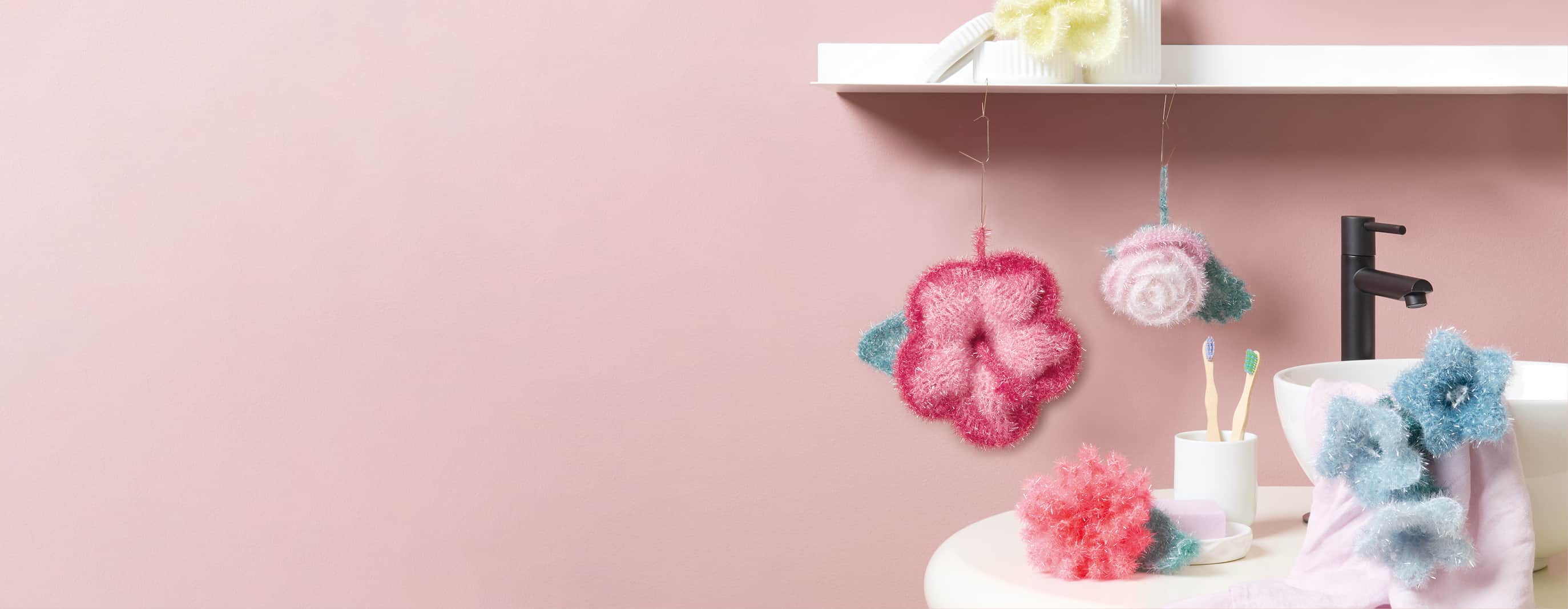 Gehäkelte Blumen-Spülschwämme hängen im Badezimmer