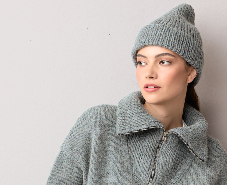Model mit Strickmütze und Strickpullover mit hohem Kragen
