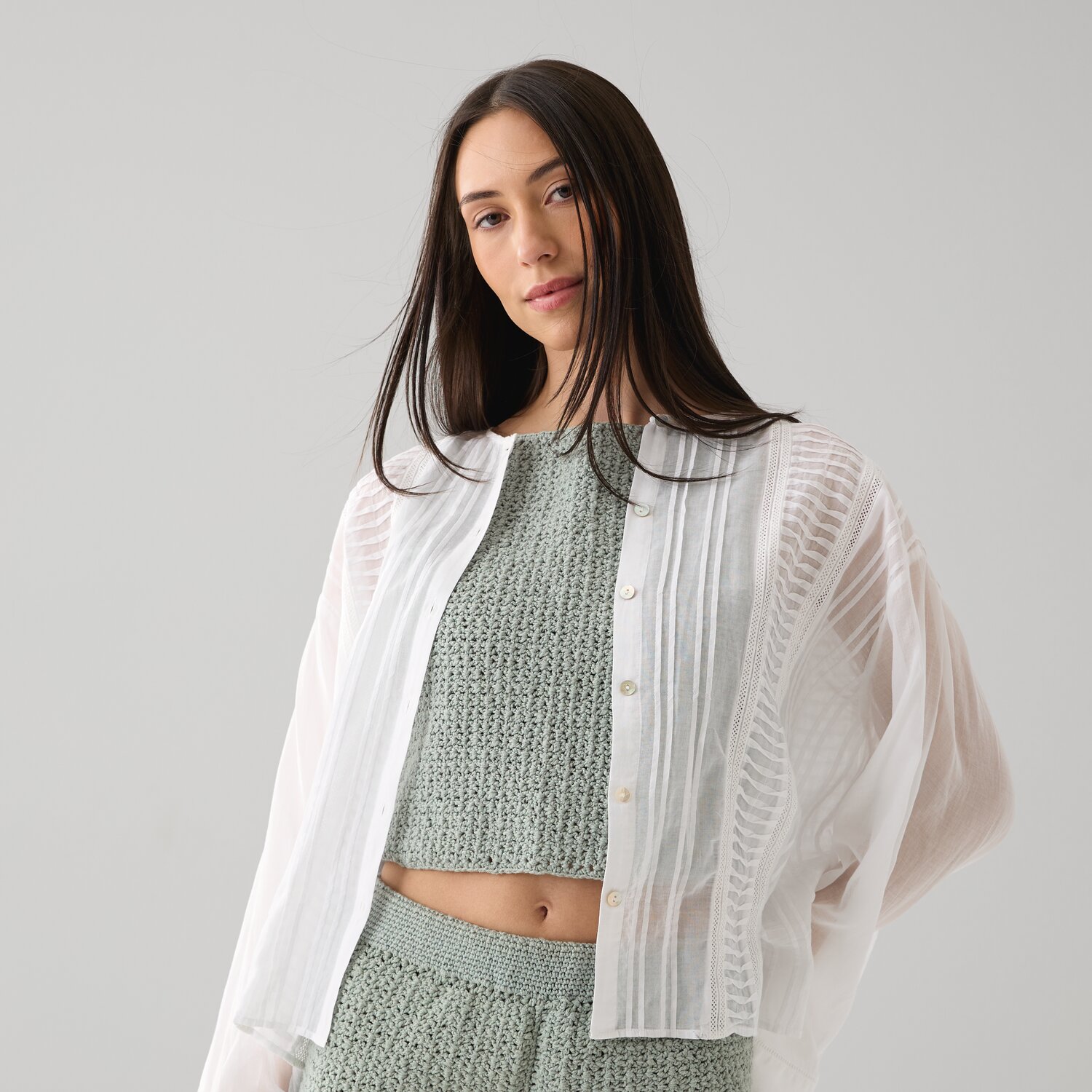 Häkelset Shorts Modell 04 B aus Die Neue Masche No. 15: Frau in grünem Häkelset mit weißer, transparenter Bluse.